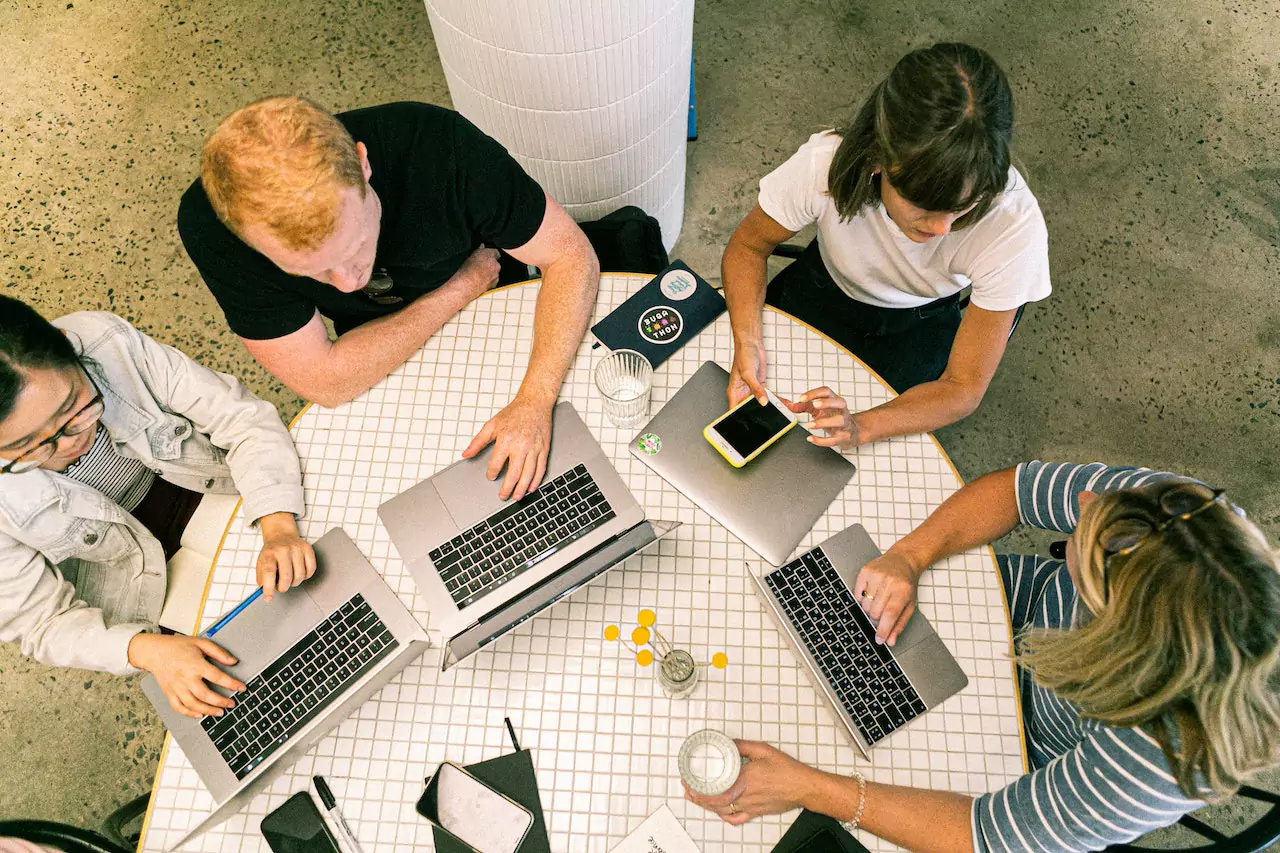 Picture of a group of people having a discussion in front of their laptops