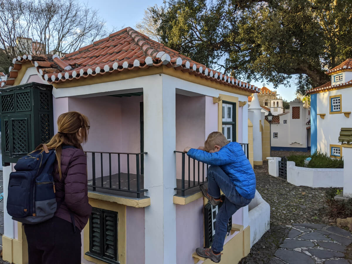 Image: The photo shows a woman with a backpack watching a child climbing an exhibit at the Portugal dos Pequenitos (Portugal for the Little Ones) theme park in Coimbra.