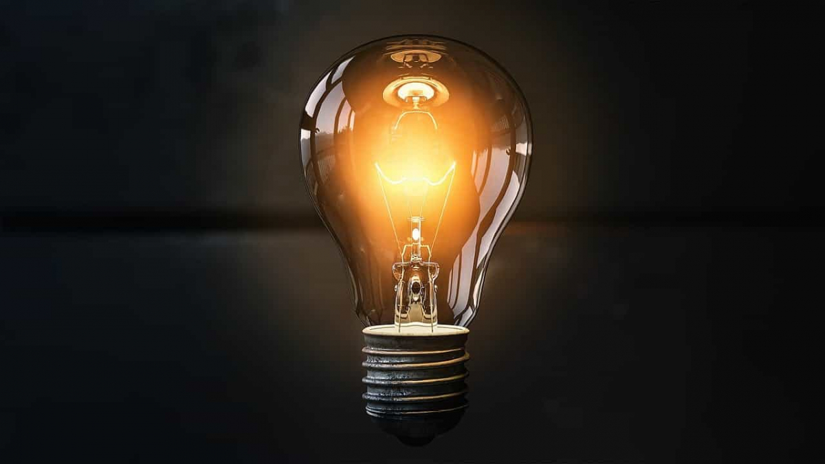 Picture of an illuminated light bulb in front of a dark background