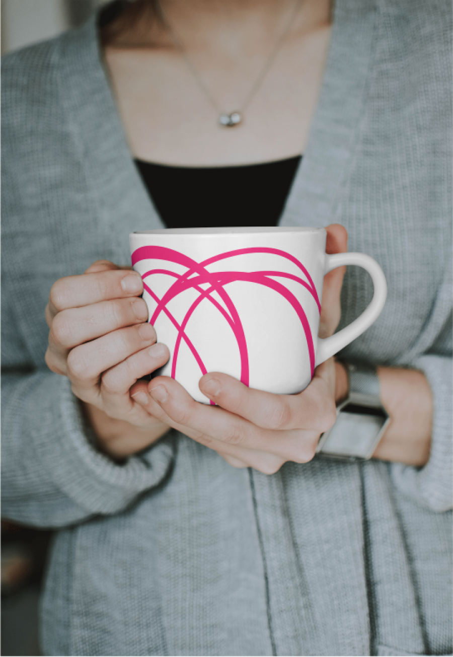 Hands of a woman holding a porcelain mug wrapped with the blogstatic brand.