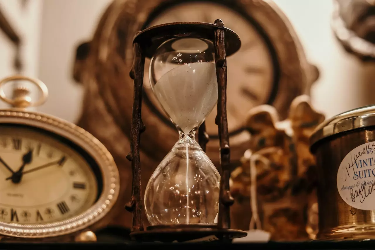 Picture of an hourglass surrounded by clocks