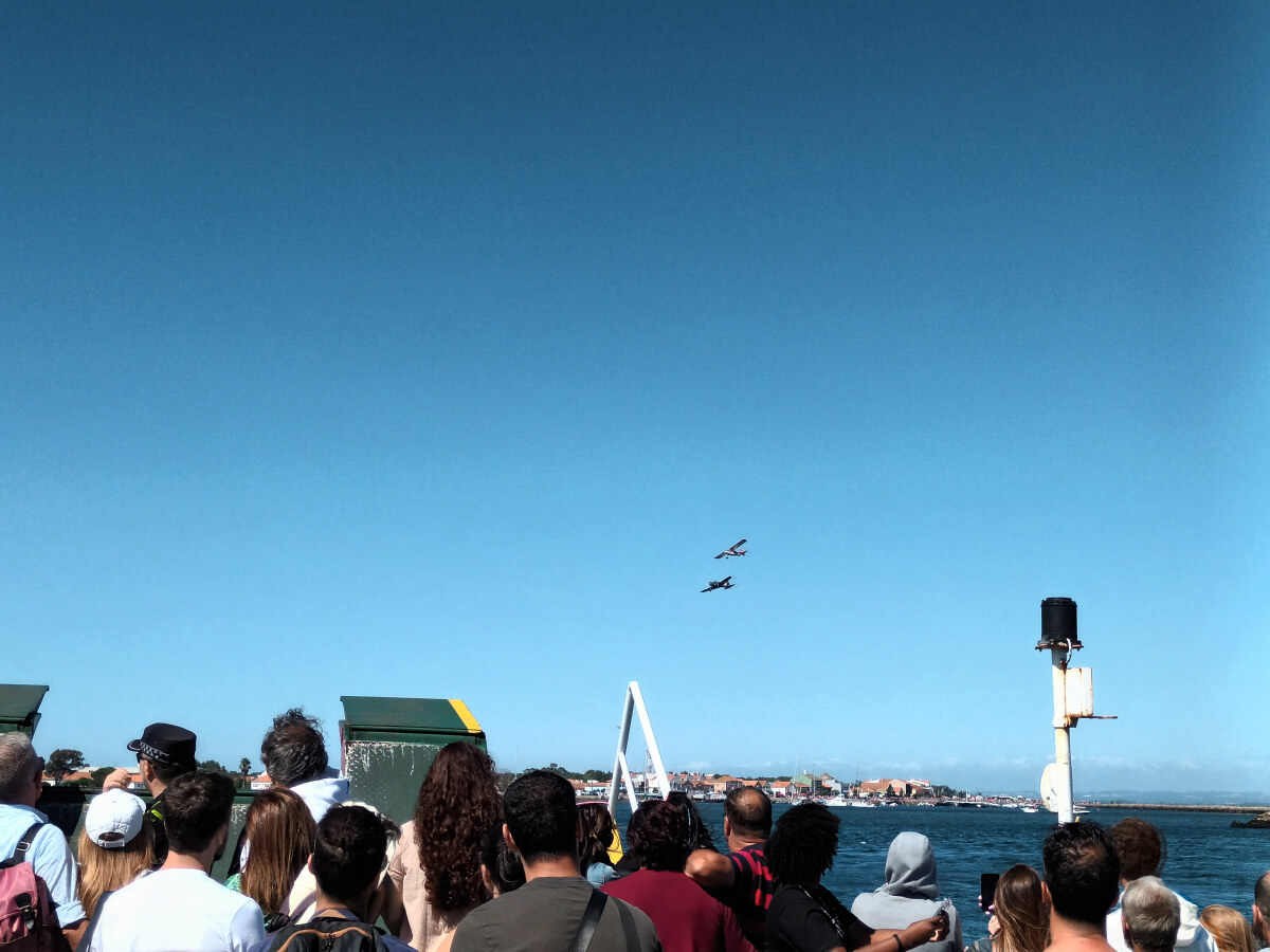 Image: The photo shows spectators watching the airshow at the 2023 Dunas Festival from the old Forte de Barra - São Jacinto ferry boat in São Jacinto, Aveiro, Portugal.