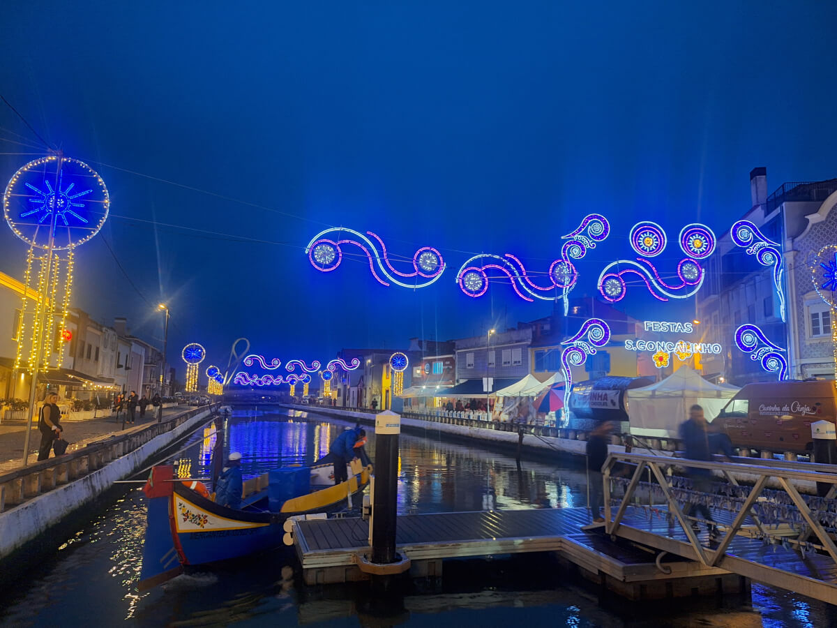 Image: The photo shows the festive illumniation of a canal in the Beira-Mar neighborhood of downtown Aveiro, Portugal.